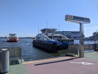 Ferry departs from dock on a sunny day.