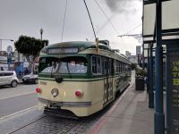 Single deck cream and green liveried trolley car.